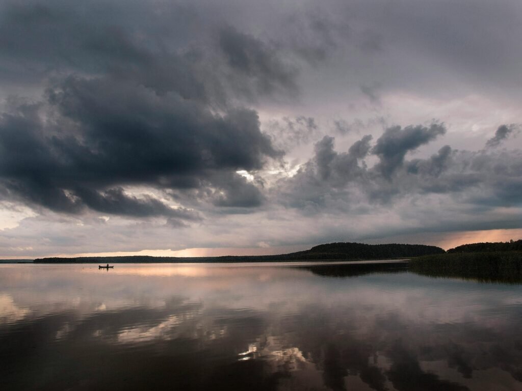 Calming sunset over Wigry Lake in Poland, showcasing a tranquil and picturesque landscape with dramatic clouds.